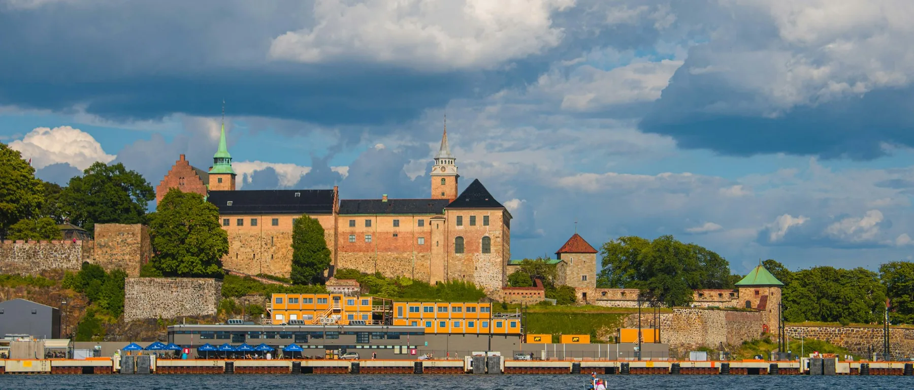 Die Akershus-Festung auf ihrem Hügel über dem Hafen unter einem zerklüfteten, bewölkten Himmel